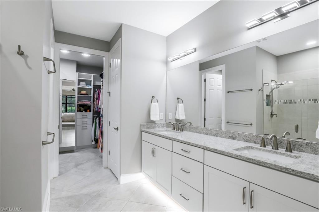 7682 Jacaranda Lane Naples, FL 34114 - Photo 9 of 30 a bathroom with a granite countertop sink mirror and shower