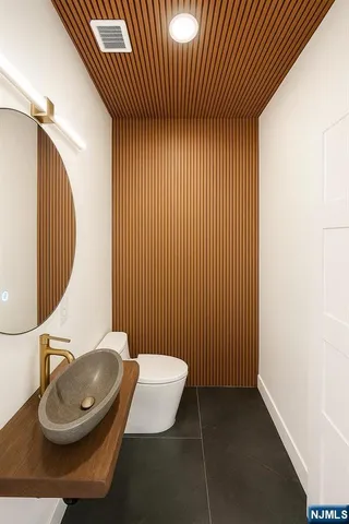 a bathroom with a sink mirror and toilet