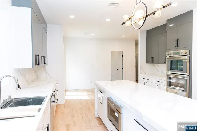 a large white kitchen with a stove a sink and dishwasher