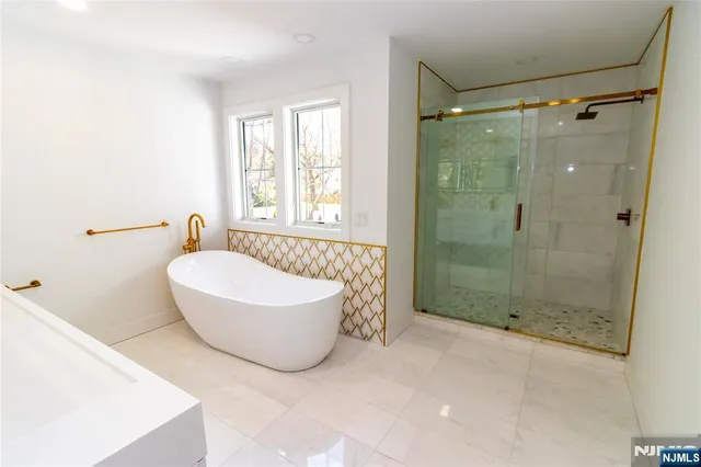 a bathroom with a tub a window and a shower