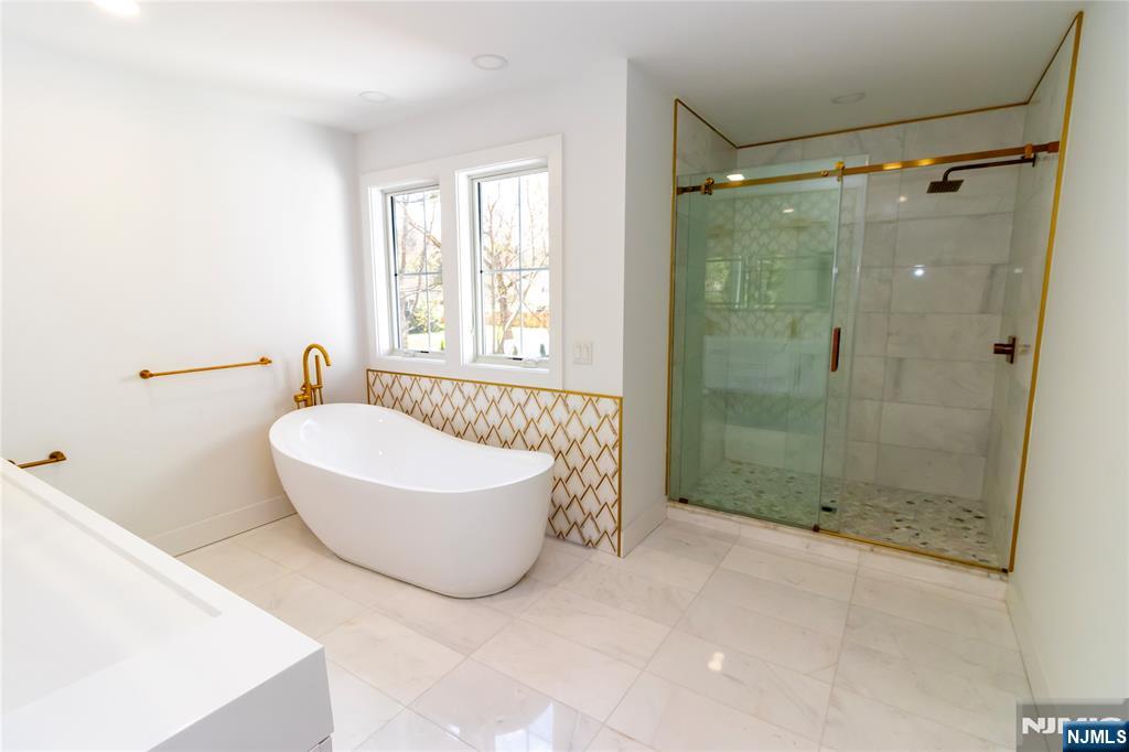 42 Harvey Street Closter, NJ 07624 - Photo 19 of 33 a bathroom with a tub a window and a shower