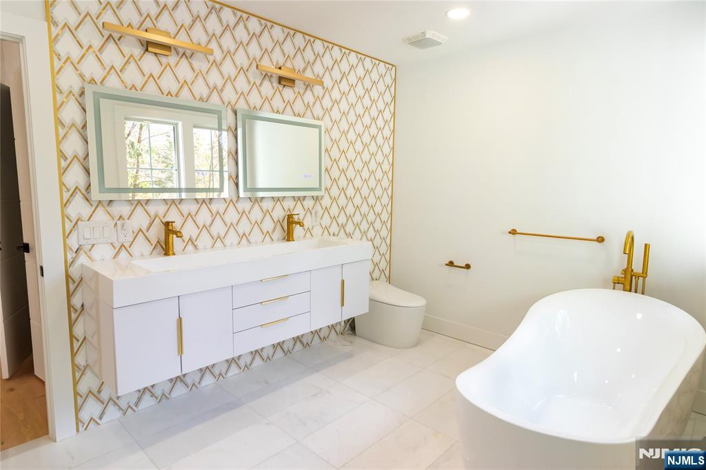 42 Harvey Street Closter, NJ 07624 - Photo 20 of 33 a bathroom with a sink mirror and a bathtub