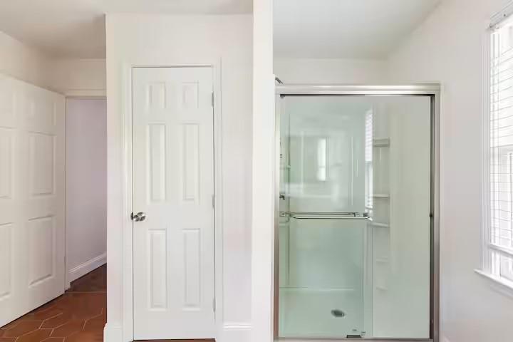 673 Windsor Street Southwest Atlanta, GA 30310 - Photo 21 of 29 a bathroom with a glass shower door
