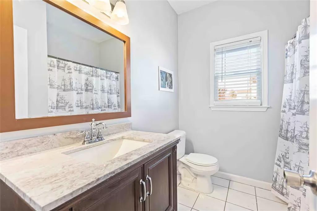 673 Windsor Street Southwest Atlanta, GA 30310 - Photo 23 of 29 a bathroom with a granite countertop sink a toilet and a window