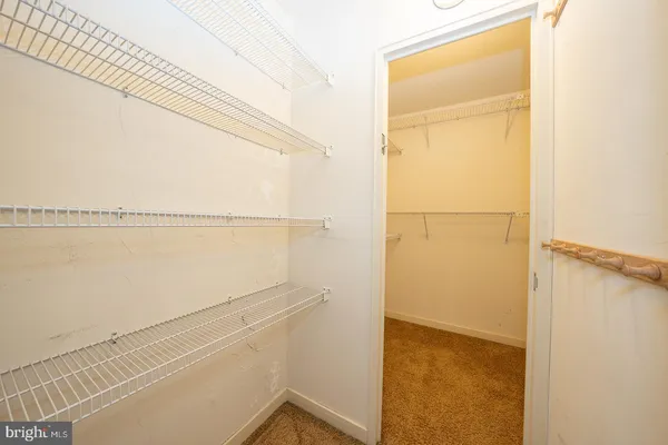 a view of walk in closet with empty racks
