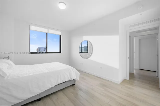 a bedroom with a bed and a painting on the wall