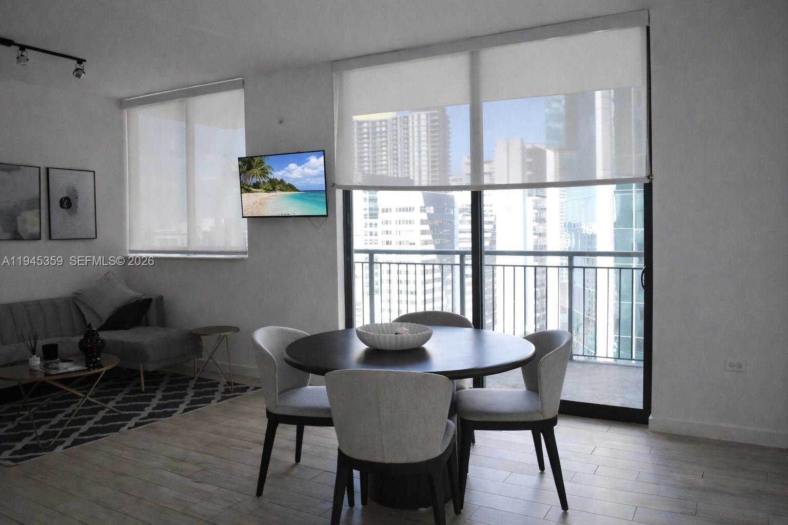 999 Southwest 1st Avenue, Unit 2214 Miami, FL 33130 - Photo 2 of 36 a view of a dining room with furniture and wooden floor