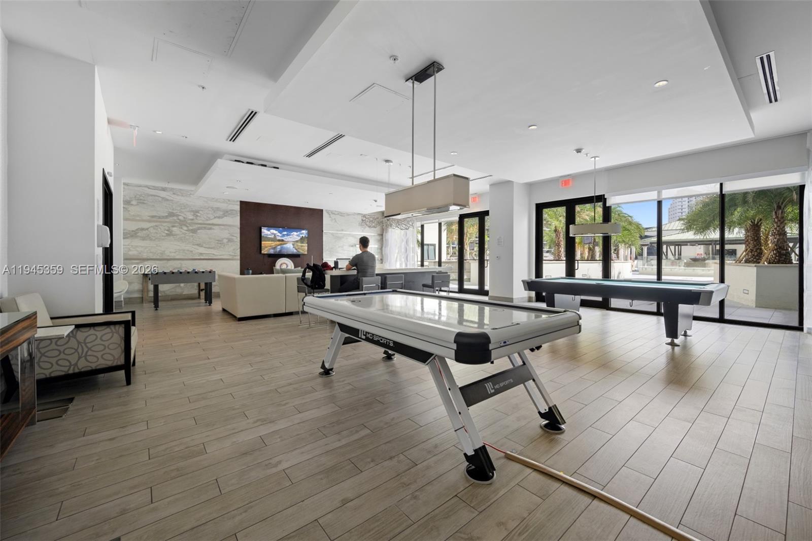 999 Southwest 1st Avenue, Unit 2214 Miami, FL 33130 - Photo 29 of 35 a living room with furniture pool table wooden floor and windows