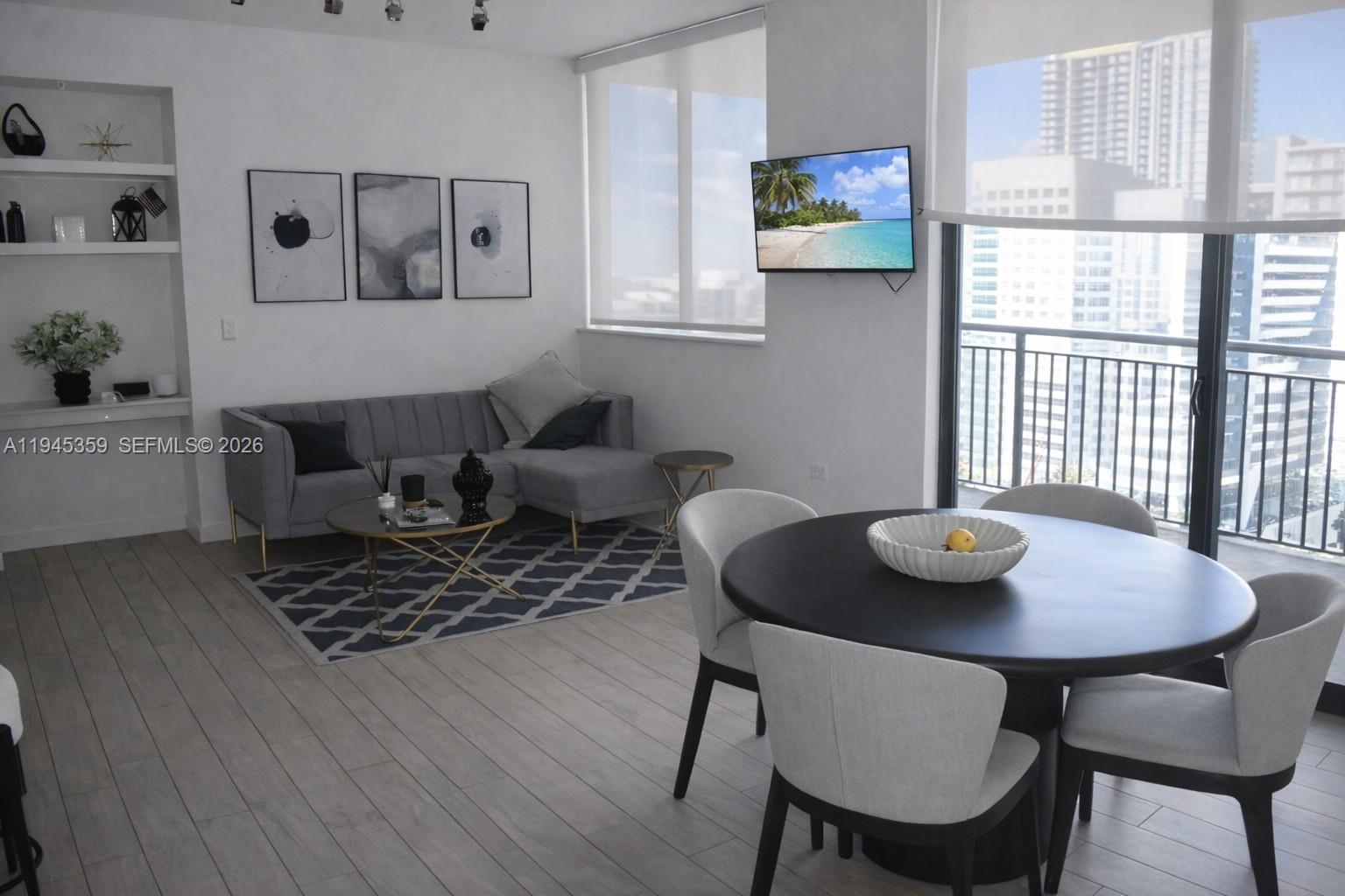 999 Southwest 1st Avenue, Unit 2214 Miami, FL 33130 - Photo 3 of 36 a view of a dining room with furniture and wooden floor