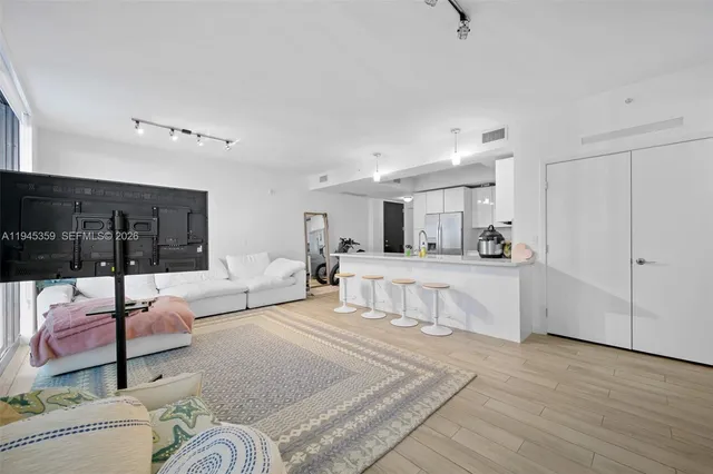 a living room with furniture and view of kitchen