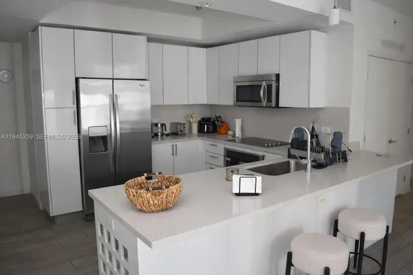 a kitchen with stainless steel appliances granite countertop a sink a refrigerator and a stove