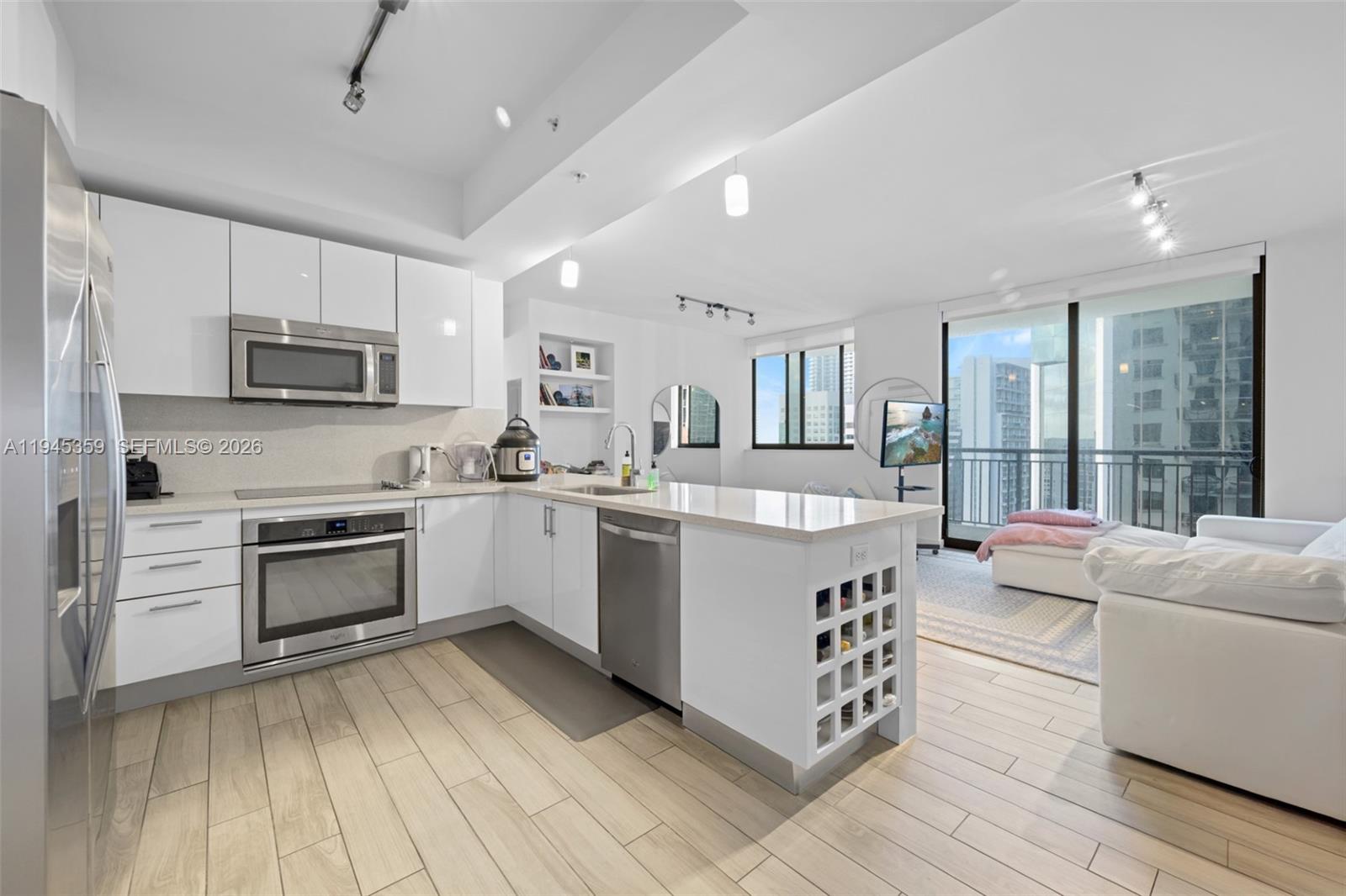 999 Southwest 1st Avenue, Unit 2214 Miami, FL 33130 - Photo 7 of 36 a kitchen with stainless steel appliances a stove a sink and a microwave