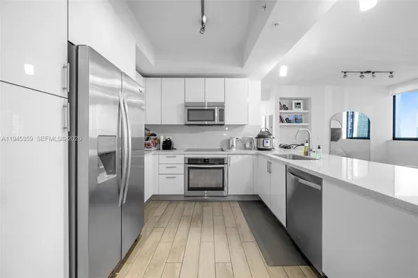 a kitchen with white cabinets and stainless steel appliances