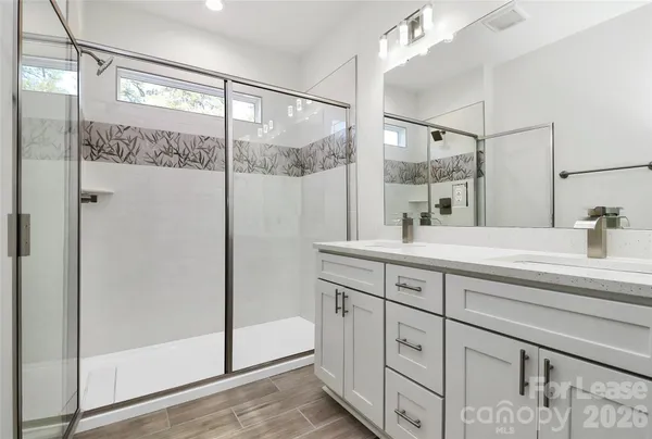 a bathroom with a shower sink and mirror