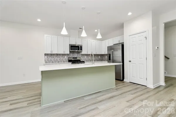a kitchen with stainless steel appliances a refrigerator sink and microwave
