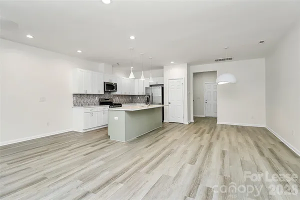 a view of kitchen with granite countertop cabinets and refrigerator