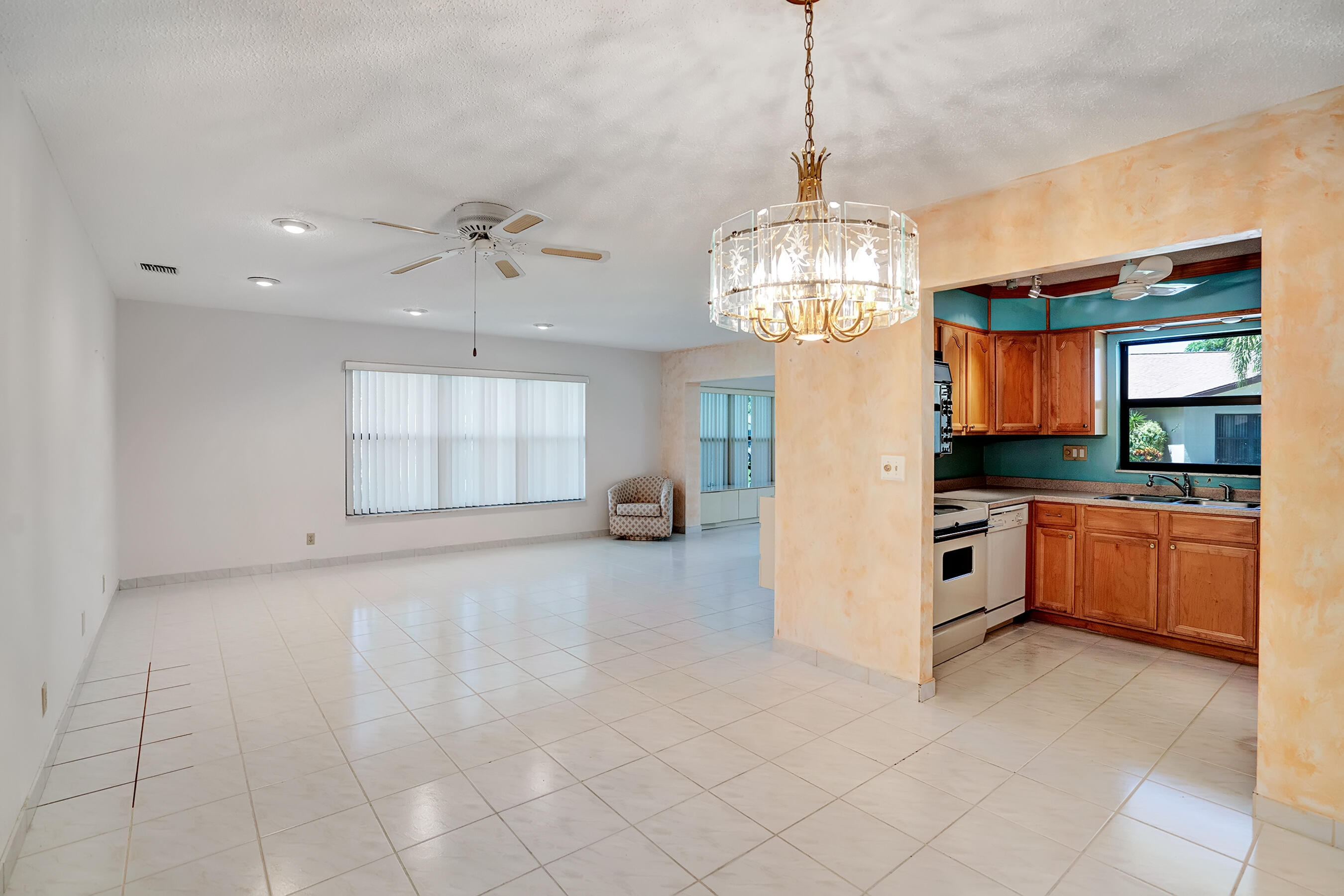 14100 Nesting Way, Unit D Delray Beach, FL 33484 - Photo 11 of 31 a view of a kitchen with granite countertop a stove top oven a sink and dishwasher with white cabinets