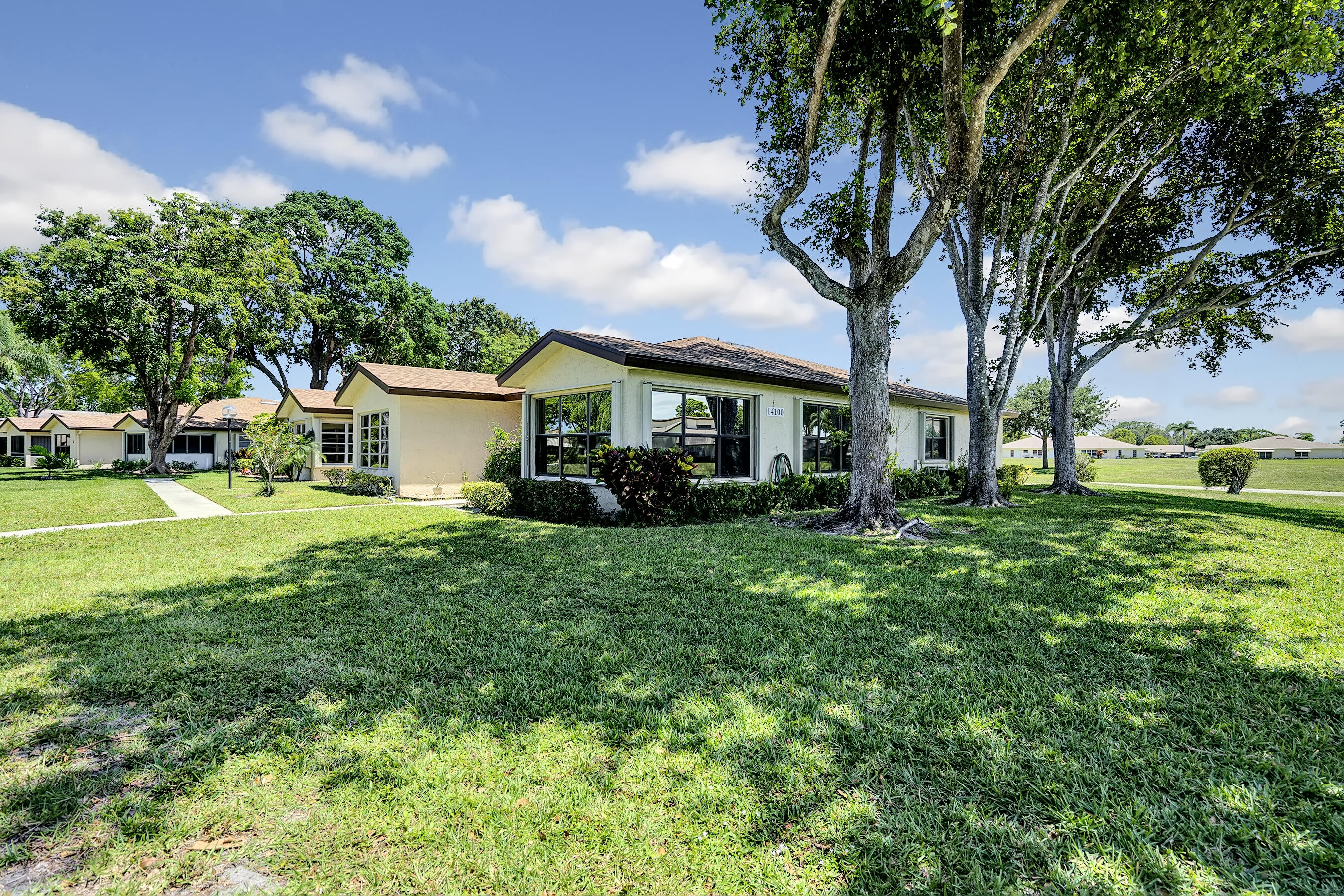 14100 Nesting Way, Unit D Delray Beach, FL 33484 - Photo 2 of 31 a front view of a house with garden and trees