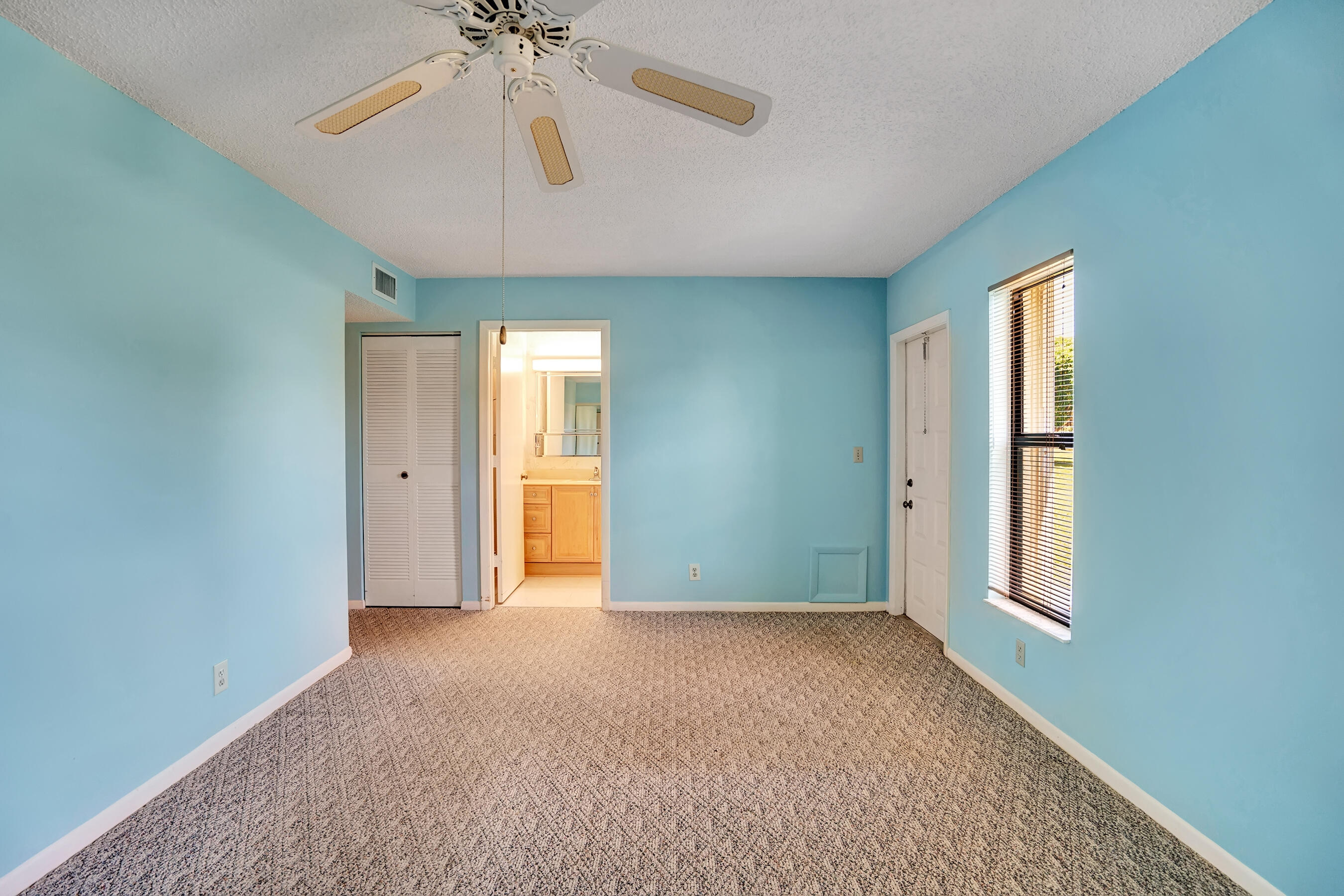 14100 Nesting Way, Unit D Delray Beach, FL 33484 - Photo 23 of 31 an empty room with chandelier fan and windows