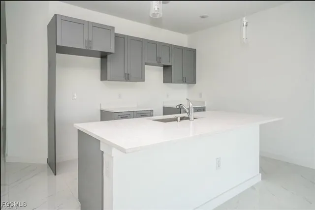 a kitchen with a sink a stove and cabinets