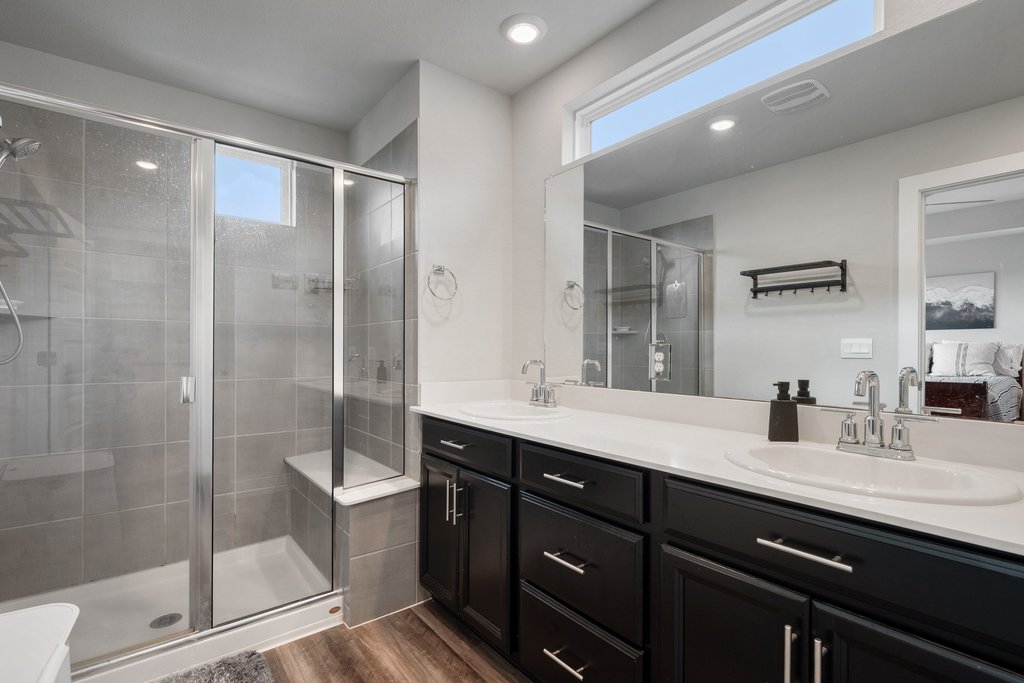 7403 Travertine Spring Drive, Unit 117 Austin, TX 78744 - Photo 27 of 37 A well-appointed bathroom features a spacious shower and a wide vanity with dual sinks, offering both style and utility.
