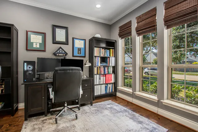 a view of a workspace with furniture and a window