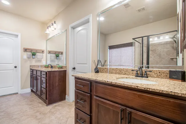 a bathroom with a granite countertop sink and a mirror