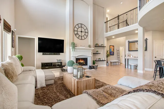 a living room with furniture a clock and a flat screen tv