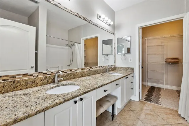 a bathroom with a granite countertop sink a toilet and shower