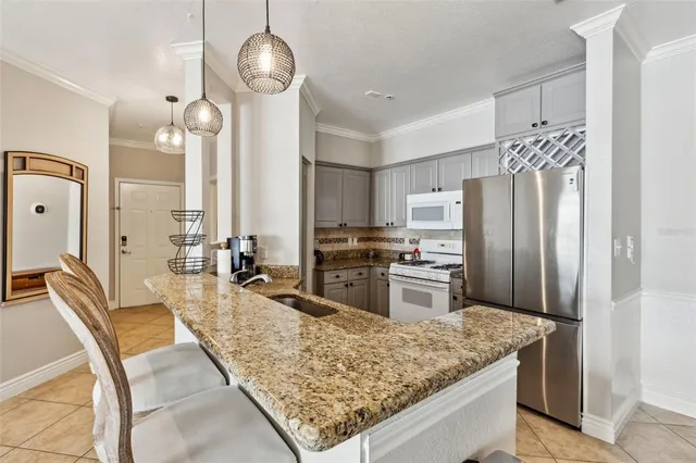 a kitchen with stainless steel appliances granite countertop a sink a stove and a refrigerator