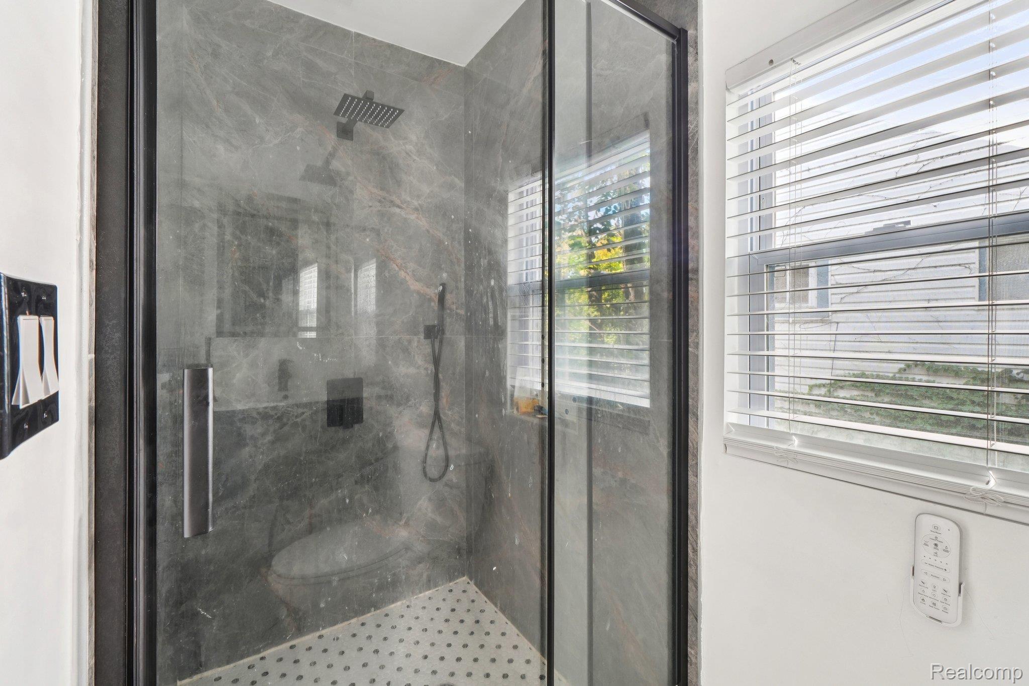 16210 Inverness Street Detroit, MI 48221 - Photo 12 of 29 Glass-enclosed shower with dark-toned wall tile, rainfall showerhead, and integrated bench