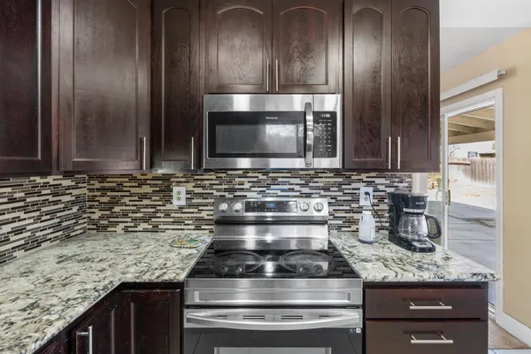 a large kitchen with stainless steel appliances kitchen island granite countertop a large counter top cabinets and stove top oven