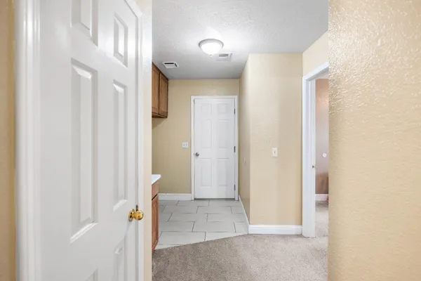 a view of an empty room with chandelier fan and fire place