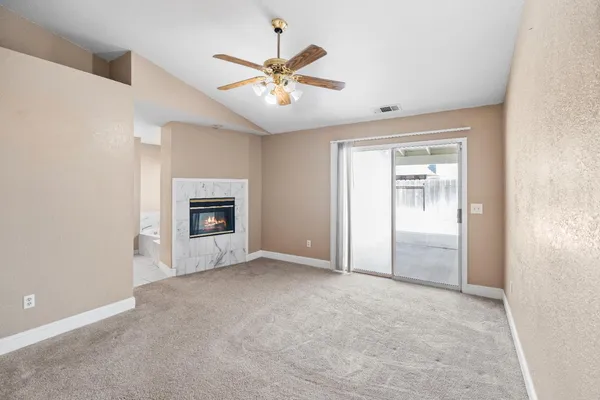 an empty room with a fireplace and a window