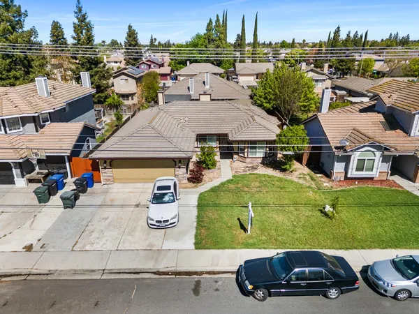 an aerial view of a house with cars parked