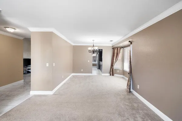 a view of empty room with window and chandelier