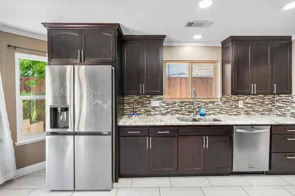 a kitchen with granite countertop stainless steel appliances wooden cabinets and a counter top