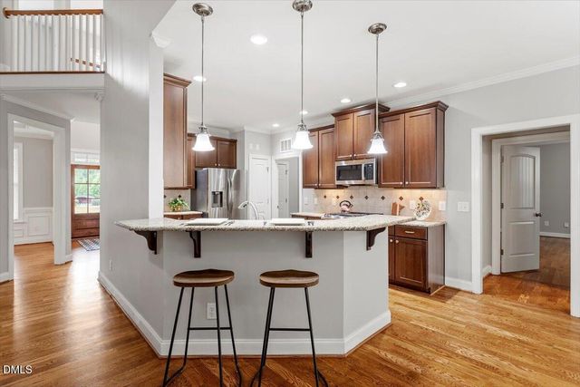a kitchen with wooden floors and stainless steel appliances