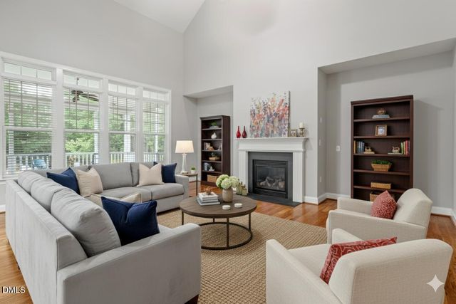 a view of an empty room with wooden floor and a fireplace