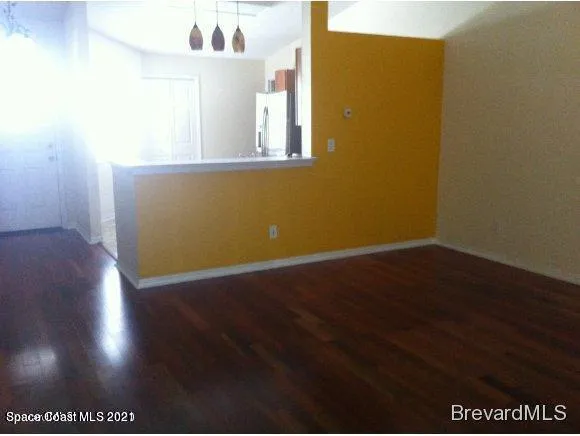 a view of a small space with wooden floor and a window