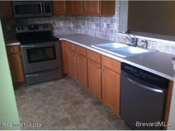 a kitchen with granite countertop a sink and a stove