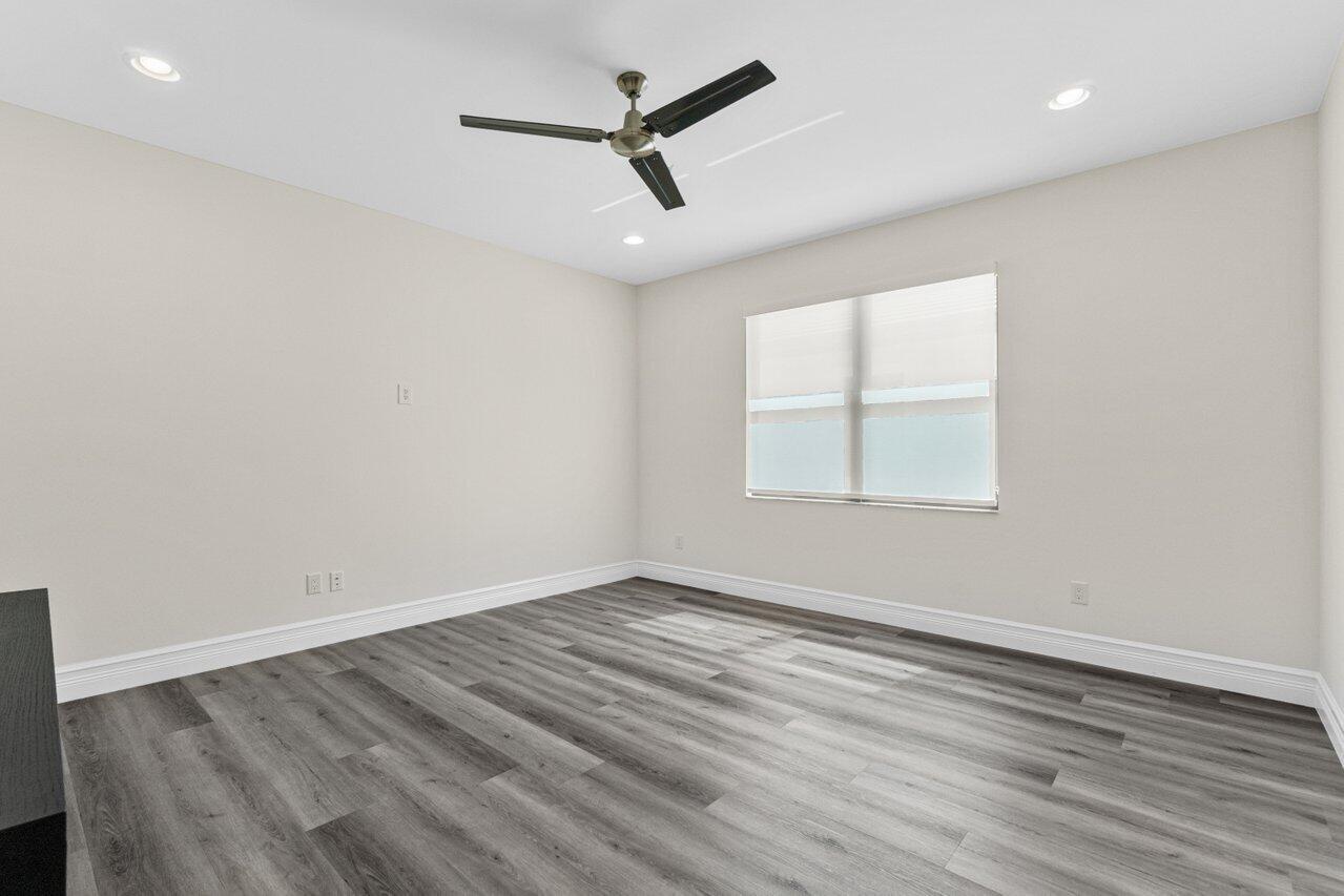 17352 Rosella Road Boca Raton, FL 33496 - Photo 27 of 41 an empty room with wooden floor ceiling fan and windows