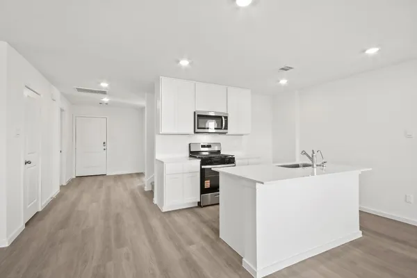 a kitchen with stainless steel appliances granite countertop a sink stove and refrigerator