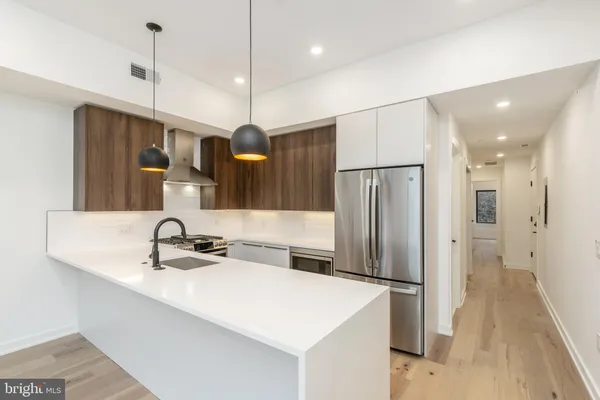 a kitchen with stainless steel appliances a refrigerator sink and microwave