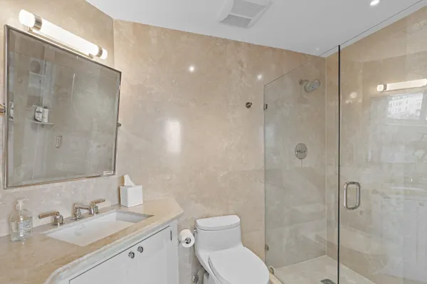 a bathroom with a toilet sink shower and mirror