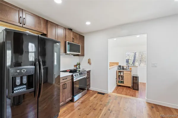 a kitchen with stainless steel appliances granite countertop a refrigerator stove and sink