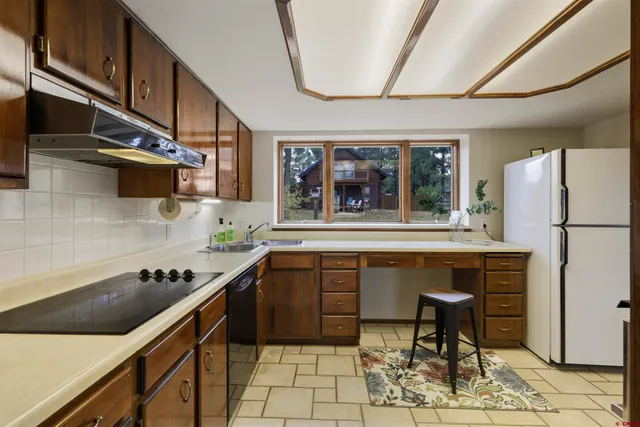 a kitchen with stainless steel appliances granite countertop a refrigerator and a stove top oven