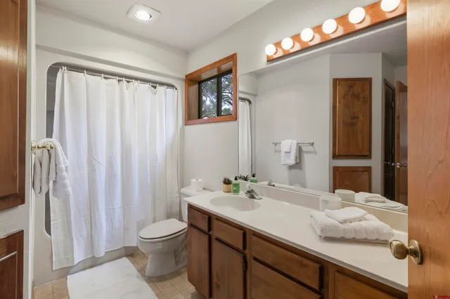 a bedroom with a large bed and a flat tv screen on dresser