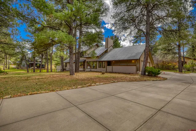 a front view of a house with a yard and trees