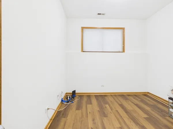 a view of a room with wooden floor and a window